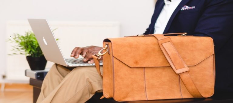 Business man uses laptop and briefcase